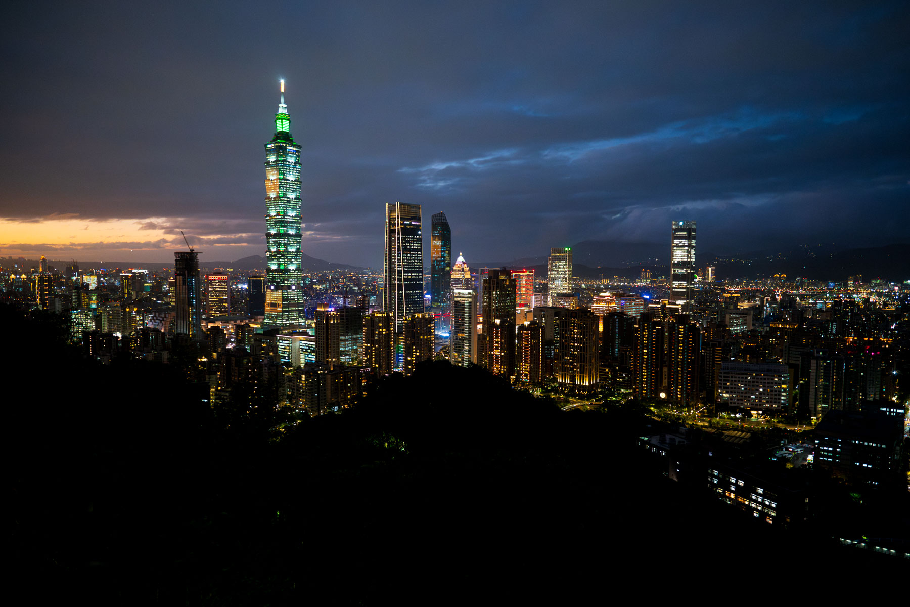 Taipei skyline at dusk with Taipei 101 illuminated above the city