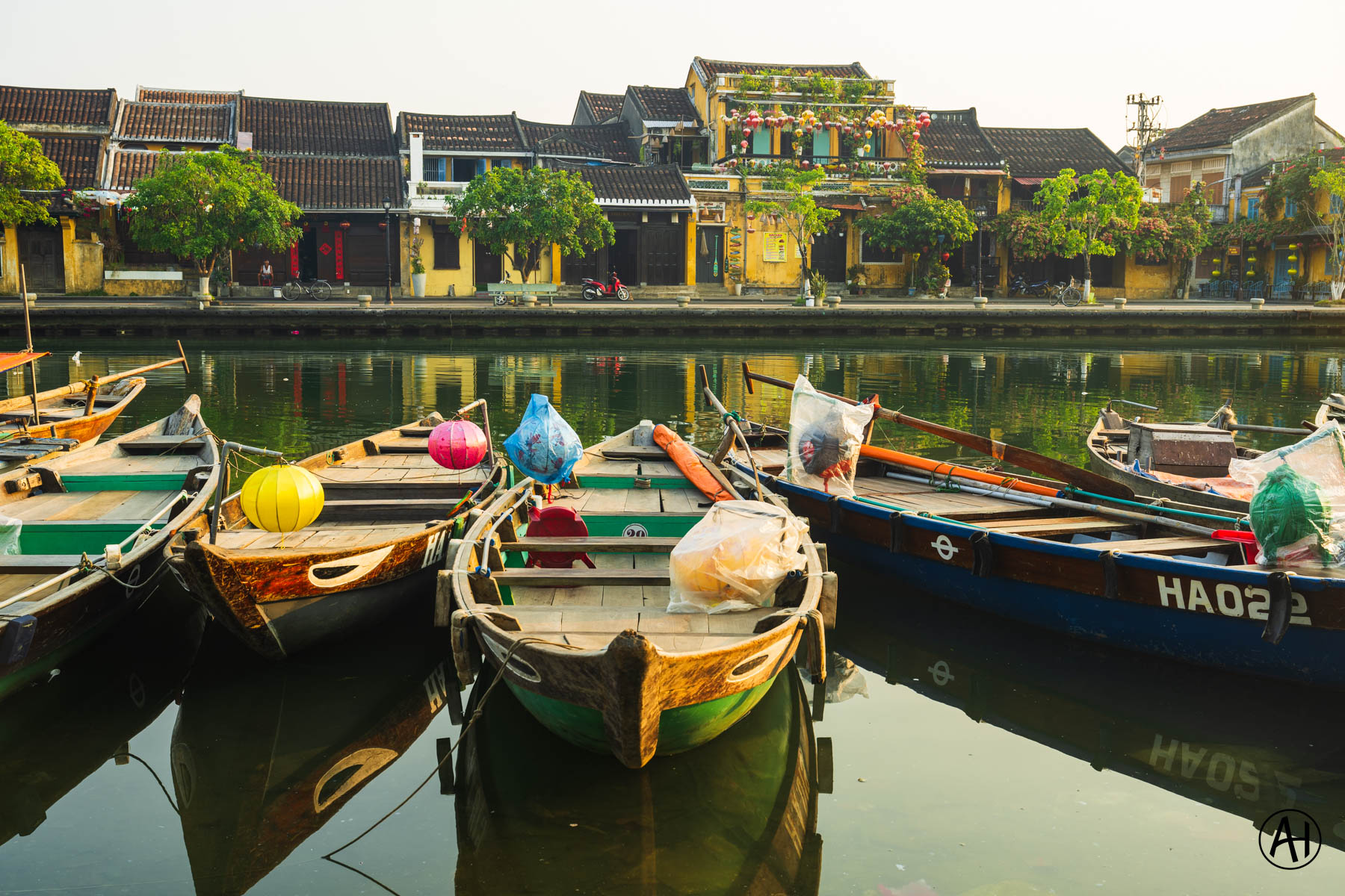 Wooden boats with colourful lanterns reflected in still waterfront water